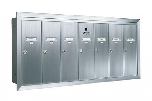 A silver, six door vertical mailbox with locks on the front. 